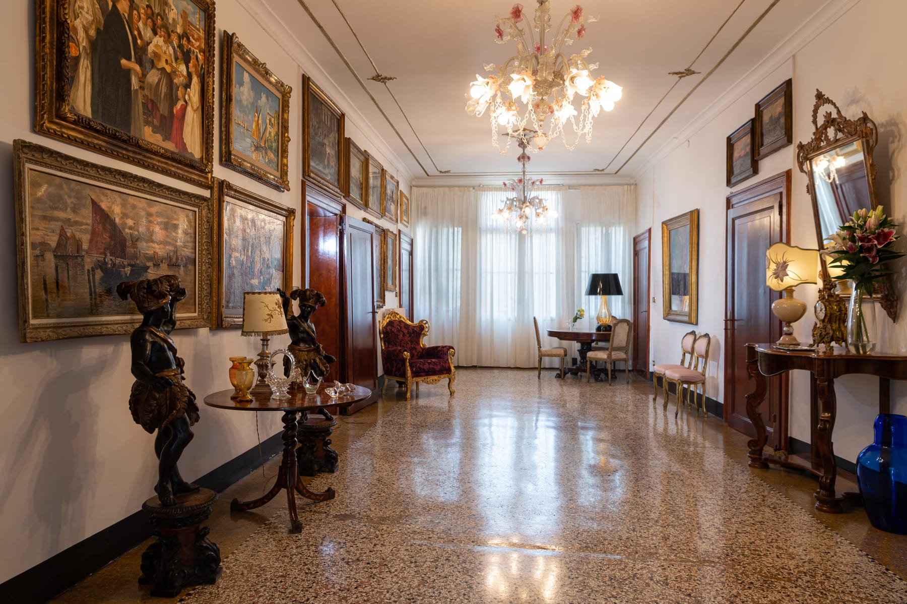 Salon vide avec lustre de Murano et salon en arrière-plan